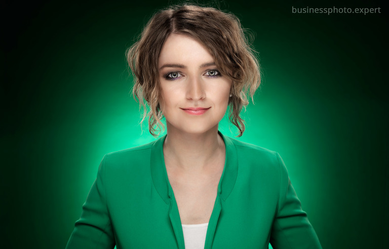 Fotografia młodej kobiety w zielonej marynarce wykonana w studio na zielonym tle przez duet Agnieszka i Dagmar Łosowscy w ADStudio